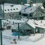 A picture of a ski resort in New Hampshire with skiers and snowboarders.