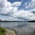 A scenic view of a lake in New Hampshire, with clouds decorating the sky.
